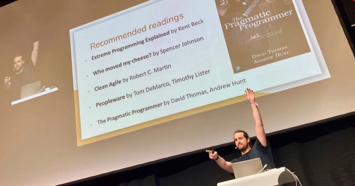 Chema on stage pointing at a recommended readings slide listing Extreme Programming Explained, Clean Agile and The Pragmatic Programmer