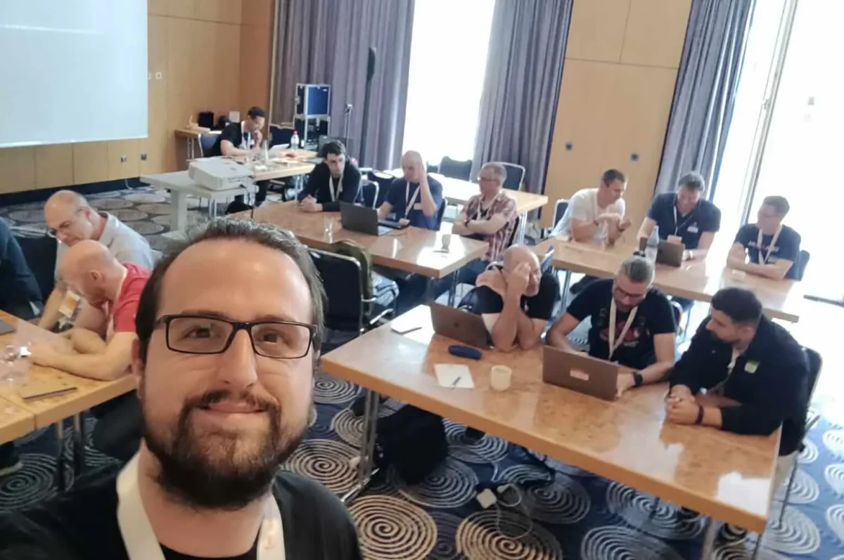 Chema in front of the TDD workshop room at International PHP Conference Berlin 2024, attendees working at laptops behind him